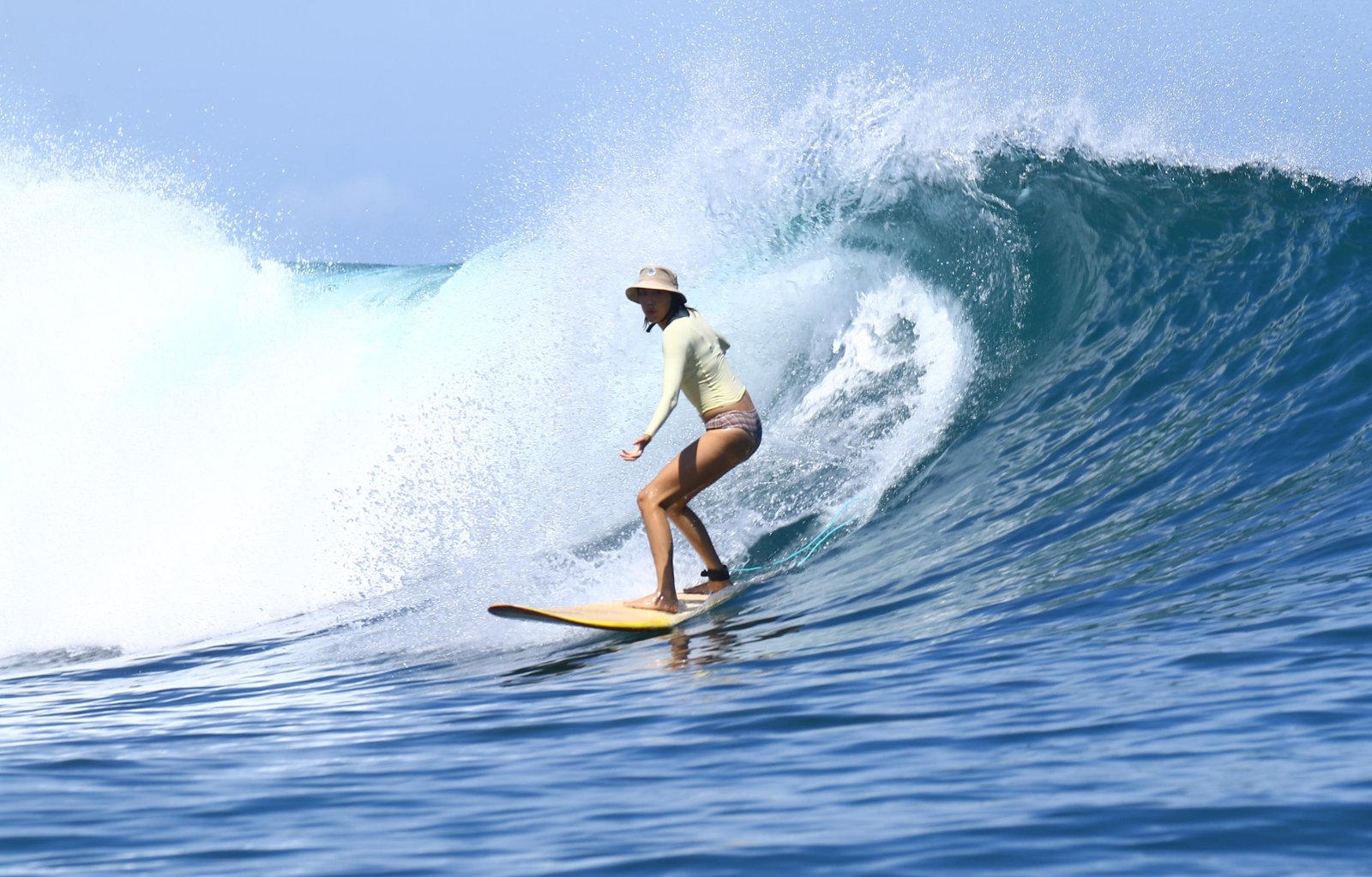 Surfer riding a longboard on a blue wave at Dreamland